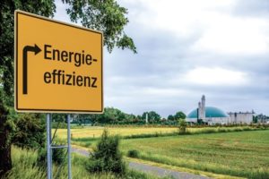 Schild mit Aufschrift Energieeffizienz führt zu einem Blockheizkraftwerk