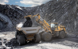 Bagger kippt Kohle aus im Bergbau mit Hydraulik