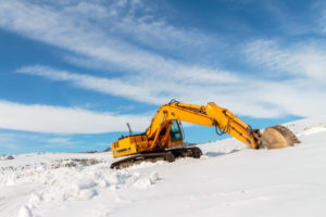 Bagger arbeitet im Schnee bei Kälte
