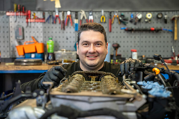Arjanit Mula arbeitet an einem Motor in seiner Werkstatt